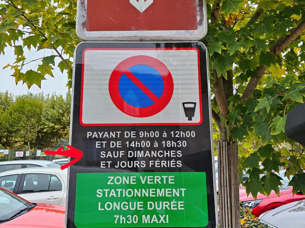 a sign on a parking lot with cars parked at Petit Duplex centre ville Montluçon 10 minutes à pieds de la gare in Montluçon