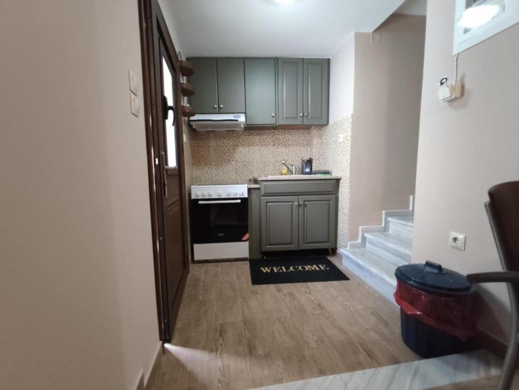 a small kitchen with green cabinets and a staircase at Kalymnos Central Port in Kalymnos