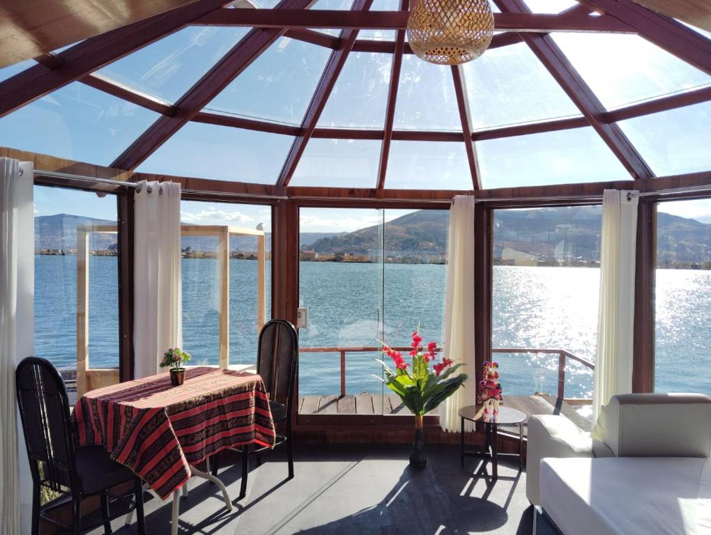 uma sala de jantar com vista para a água em Uros encantos del titikaka lodge em Puno