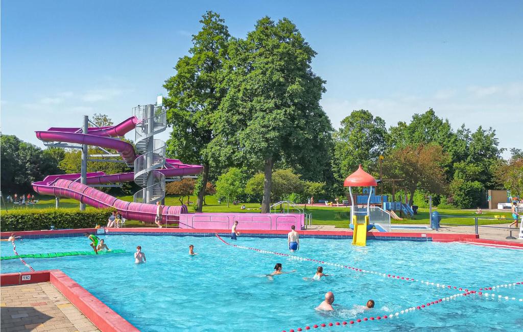 a group of people in a swimming pool with a water slide at 2 Bedroom Cozy Home In Heinkenszand in Graszode