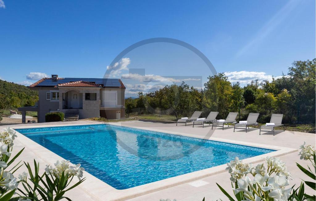 a swimming pool with chairs and a house at Stunning Home In Trogir in Prapatnica