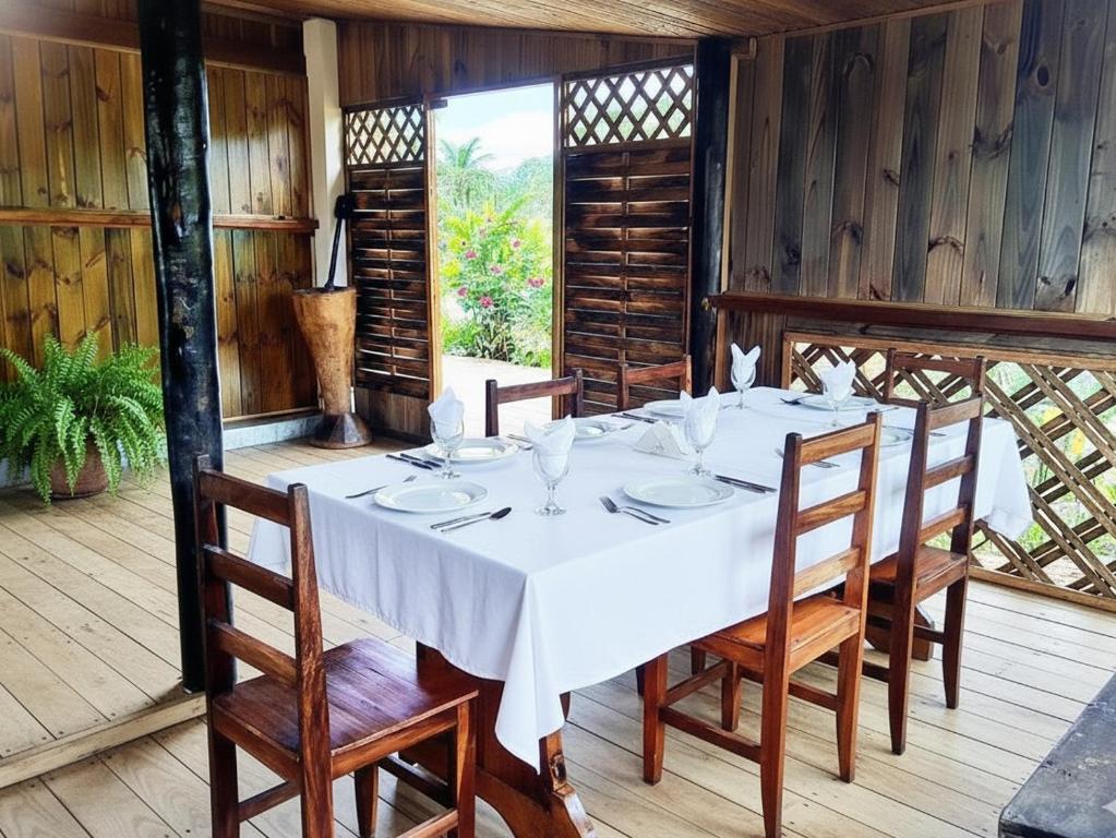 Un comedor con una mesa y sillas blancas. en Pousada Ilha Sul, en Cananéia