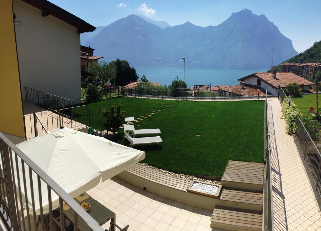 a balcony with an umbrella and a lawn with mountains at Anna Apartments in Castro