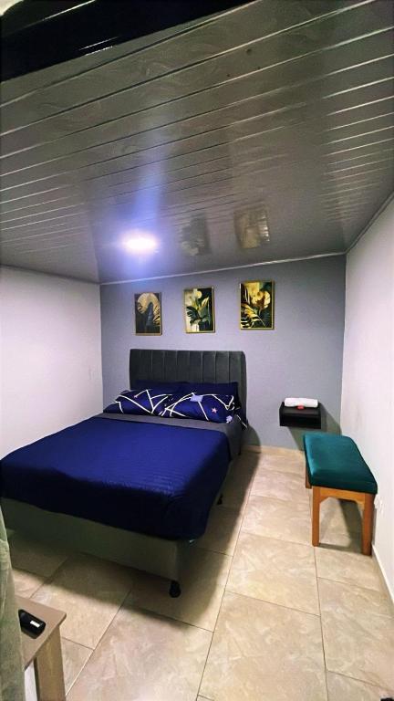 a bedroom with a blue bed and a chair at Vélez Loft II in Vélez