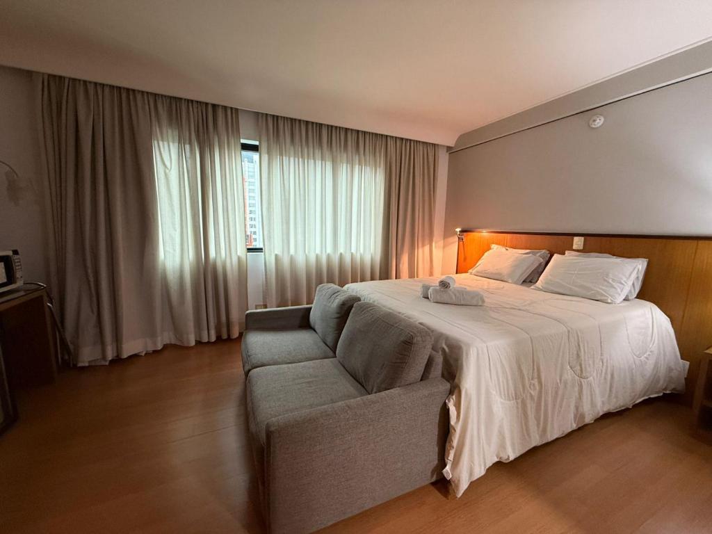 a hotel room with a bed and a couch at Suíte 5 estrelas Hotel Av Ibirapuera 2534 Moema - 1 in Sao Paulo