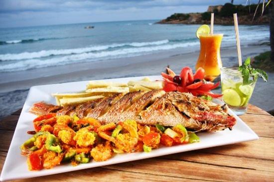 talerz ryb z frytkami na stole niedaleko plaży w obiekcie Caribessa é Aqui !!! w mieście João Pessoa