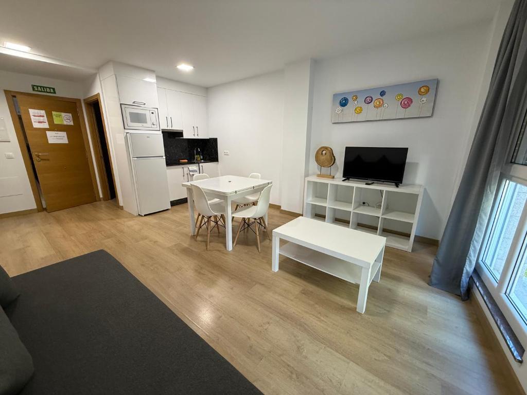 a living room with a white table and a kitchen at SF40 Vut in Lugo
