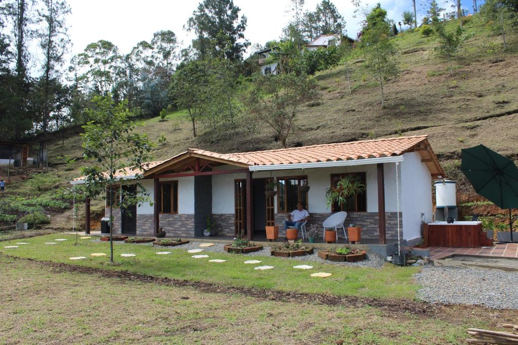 a small house with a person standing in front of it at Alma Farm House in San Vicente