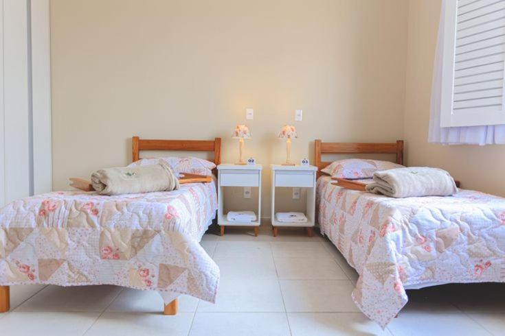a bedroom with two beds and two night stands at Pousada América Aeroporto Viracopos Campinas in Viracopos
