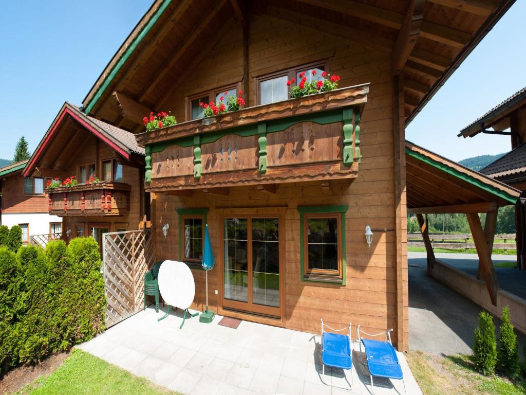 a house with blue chairs in front of it at Holiday Village Wildschönau Chalet with Terrace, cleaning included in Niederau