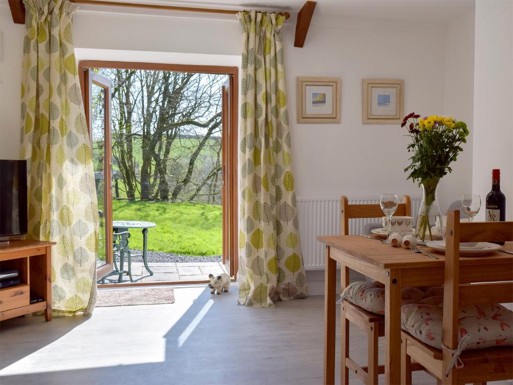 comedor con mesa y puerta corredera de cristal en Parlwr - Uk11210, en Cwrt-newydd