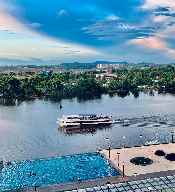 古晋LoFF Suite River View 2 Bedroom at Kuching Riverine Resort的一条船上的人