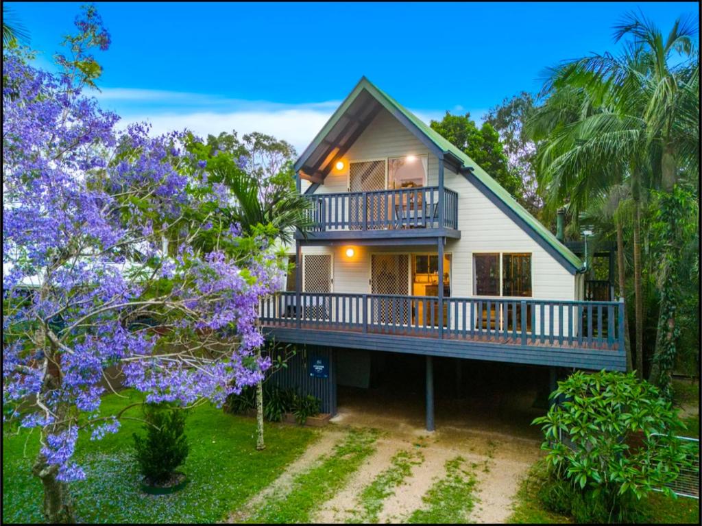 ein weißes Haus mit einem Balkon und Bäumen in der Unterkunft Wooli Cottage Retreat in Wooli