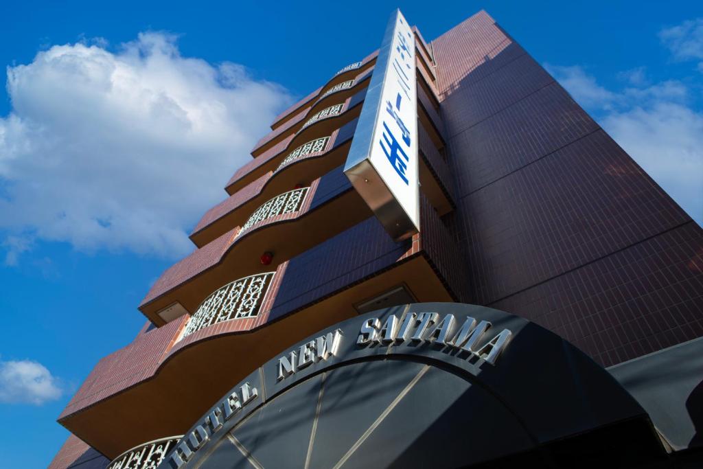 a tall building with a sign on top of it at Hotel New Saitama in Saitama