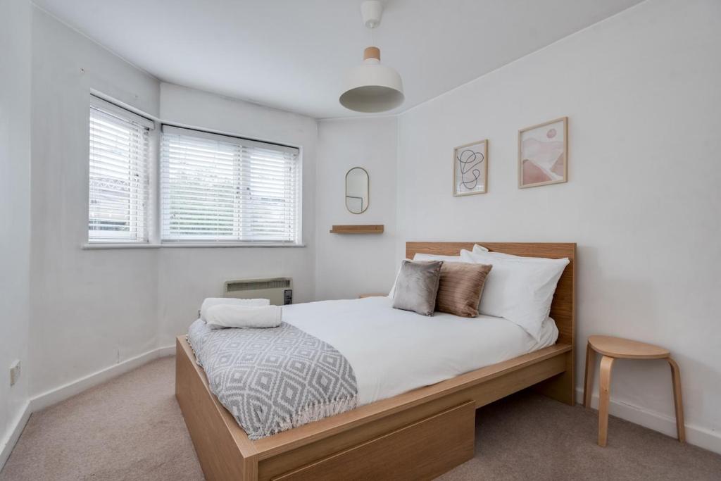 une chambre avec un lit avec des murs et des fenêtres blancs dans l'établissement Central Oxford Oasis - Close to Colleges and Shops, à Oxford