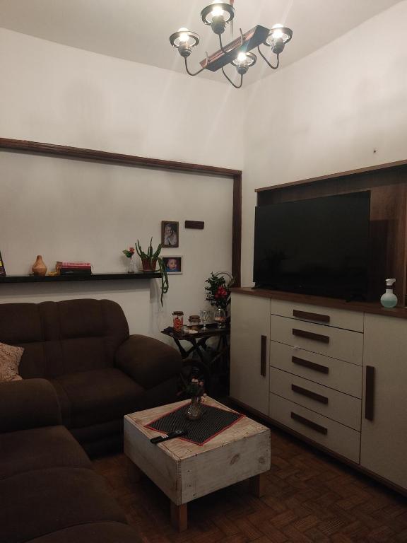 un salon avec un canapé et une télévision à écran plat dans l'établissement Cozy Retro Apartment!, à Pasto da Mata