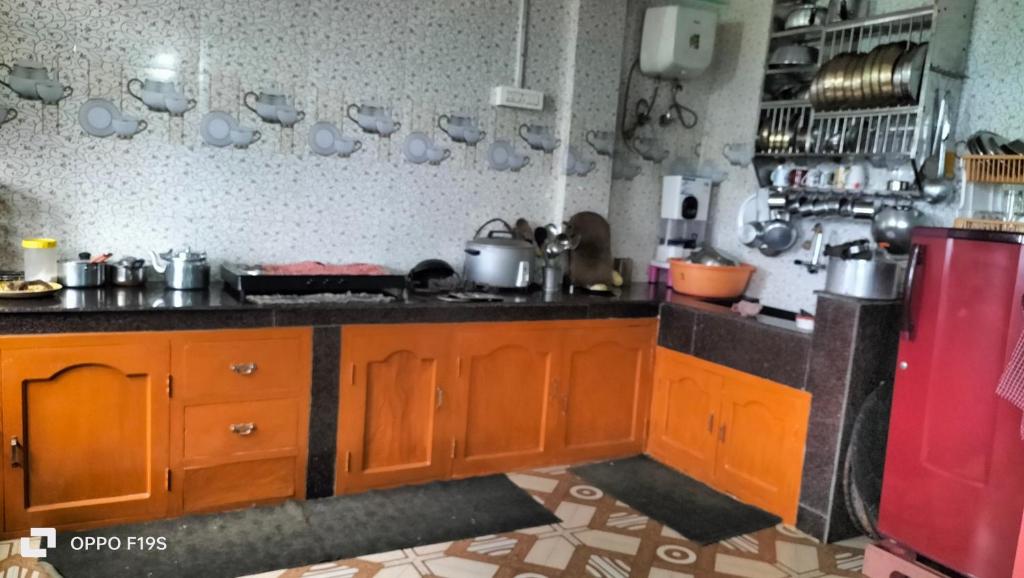 cocina con armarios de madera y nevera roja en Chyajalo homestay, en Darjeeling