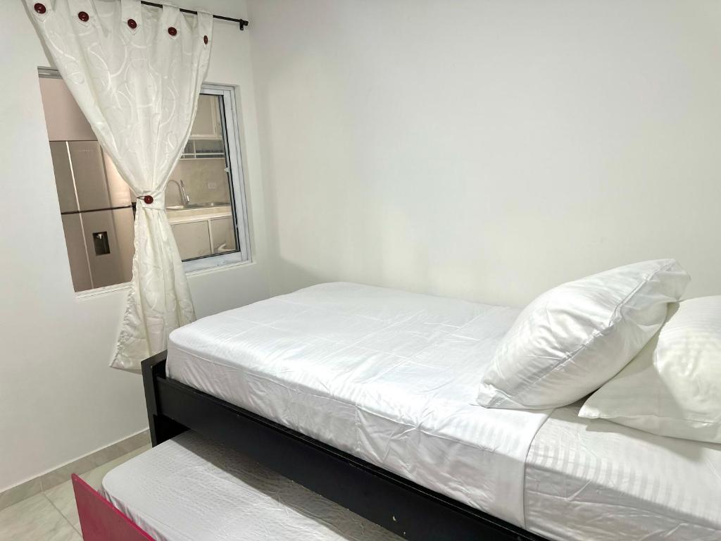 a bedroom with a white bed with a window at Apartamento vacacional por días en Santa Marta in Santa Marta