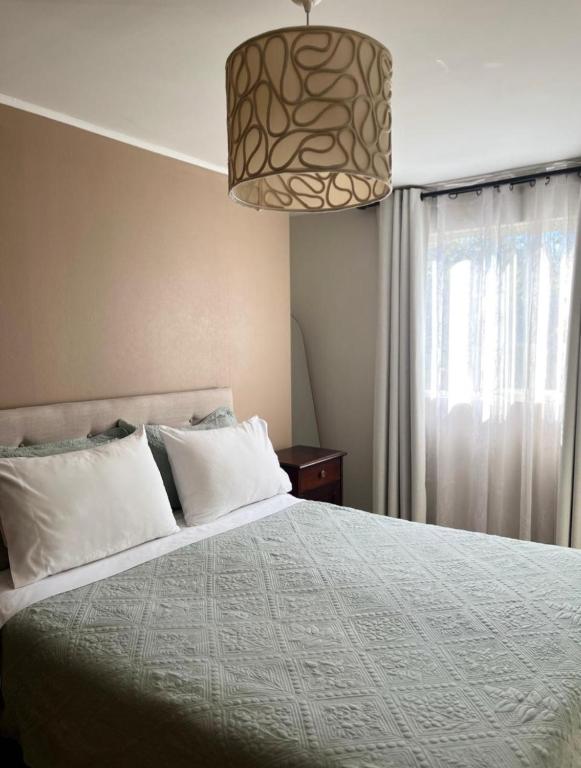 a bedroom with a bed and a pendant light at Hostal Abrazo de Maipu in Santiago