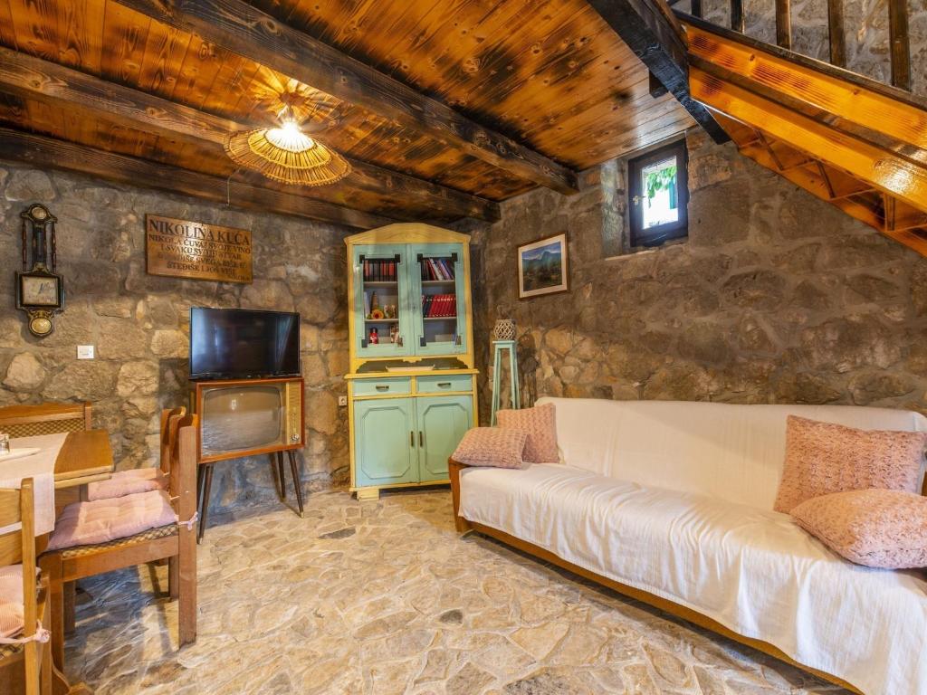 a living room with a couch and a table at Rustical Resort Kokori i Shared Pool - One Bedroom in Višnjica