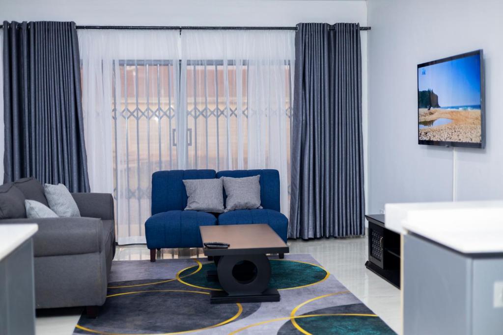 a living room with a blue couch and a table at The Parresia Haven in Harare