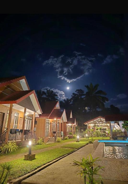 a group of houses at night with the moon at Cinta Abadi Resort in Bidur