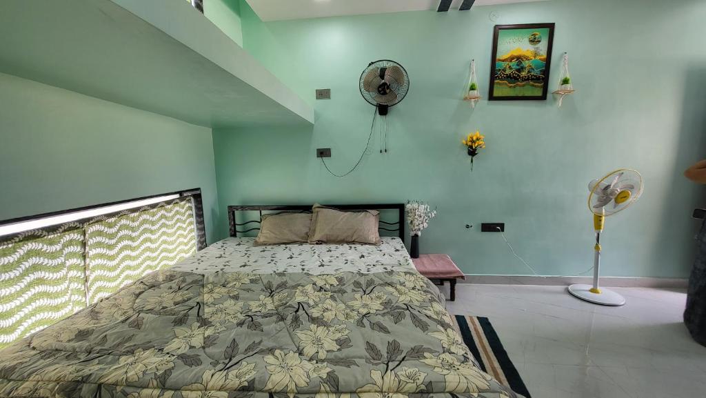 a bedroom with a bed and a fan at Private room in a residential area in Hospet