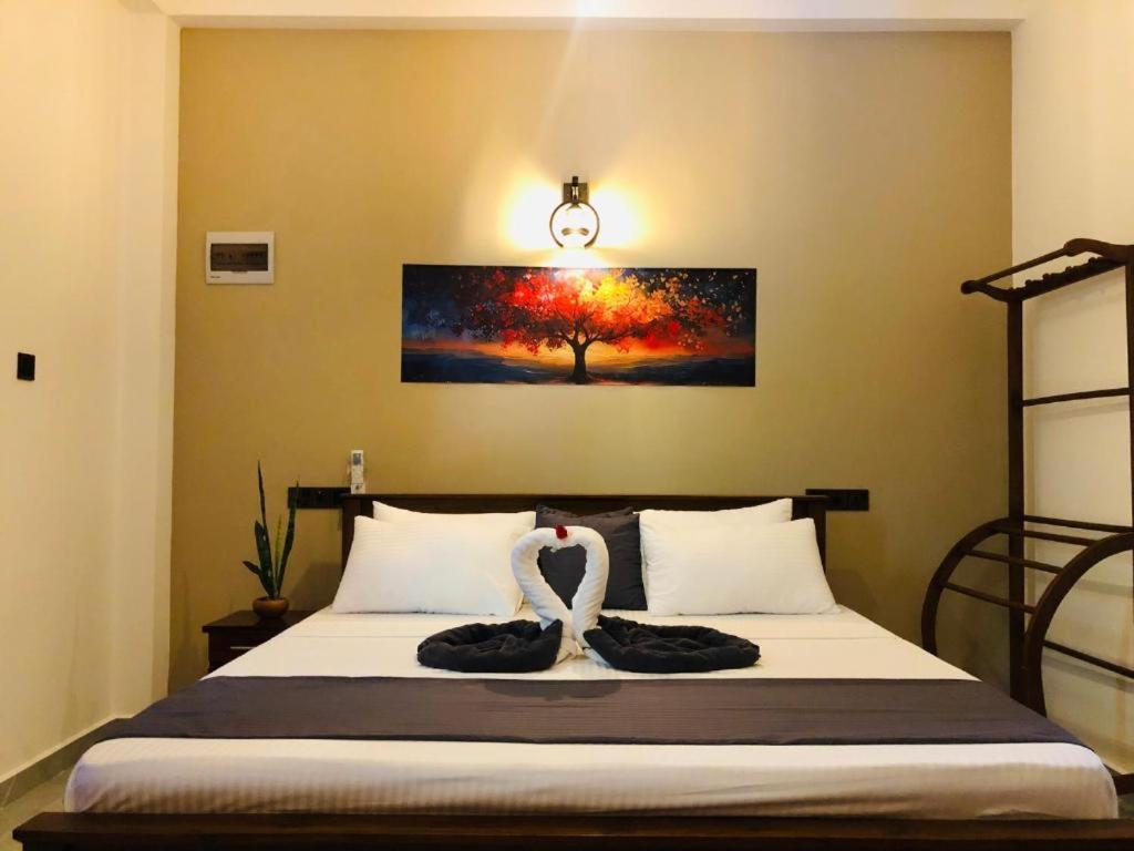 a bedroom with a bed with two swans on it at Hiriketiya Green Haven Villa in Dickwella