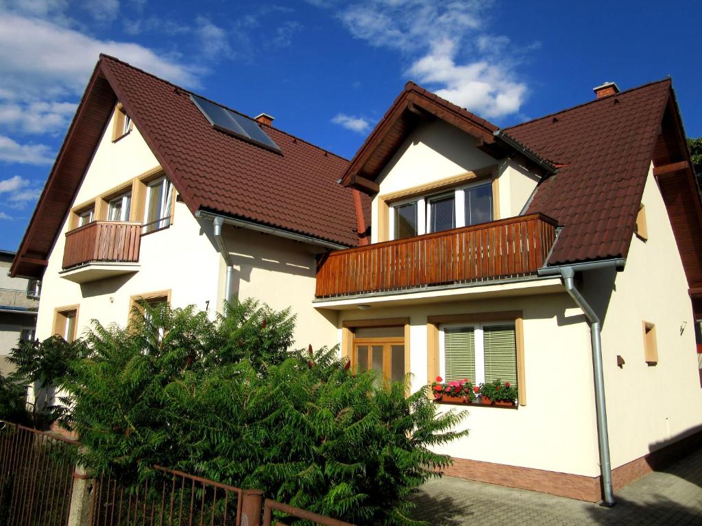 een wit huis met een bruin dak bij Apartments Centrum in Liptovský Mikuláš