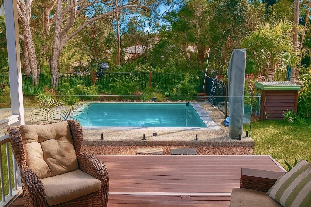 Weyba DownsにあるStunning Modern Queenslander, steps to Lakeの椅子付きの庭のスイミングプール