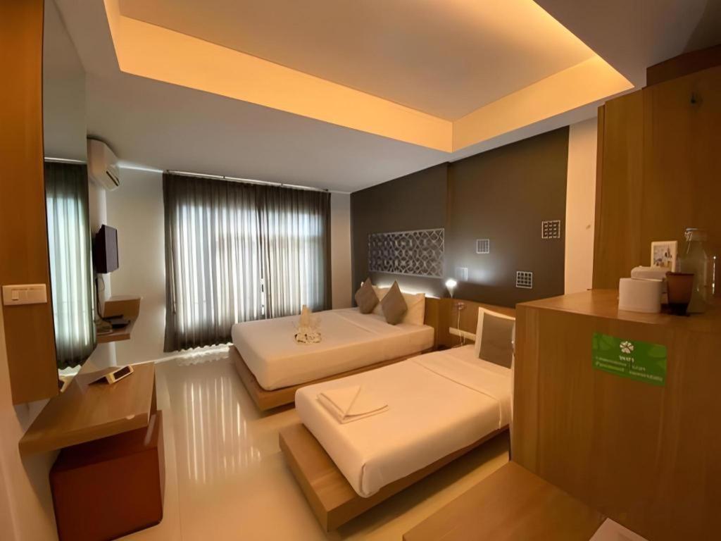 a large room with two beds in a room at Tonkok Hotel in Chiang Rai