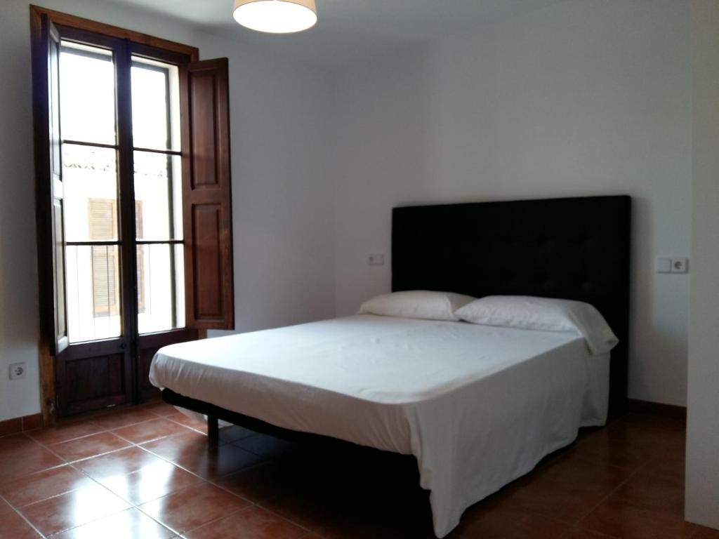 um quarto com uma cama grande num quarto com janelas em Can Mayol em Alaró