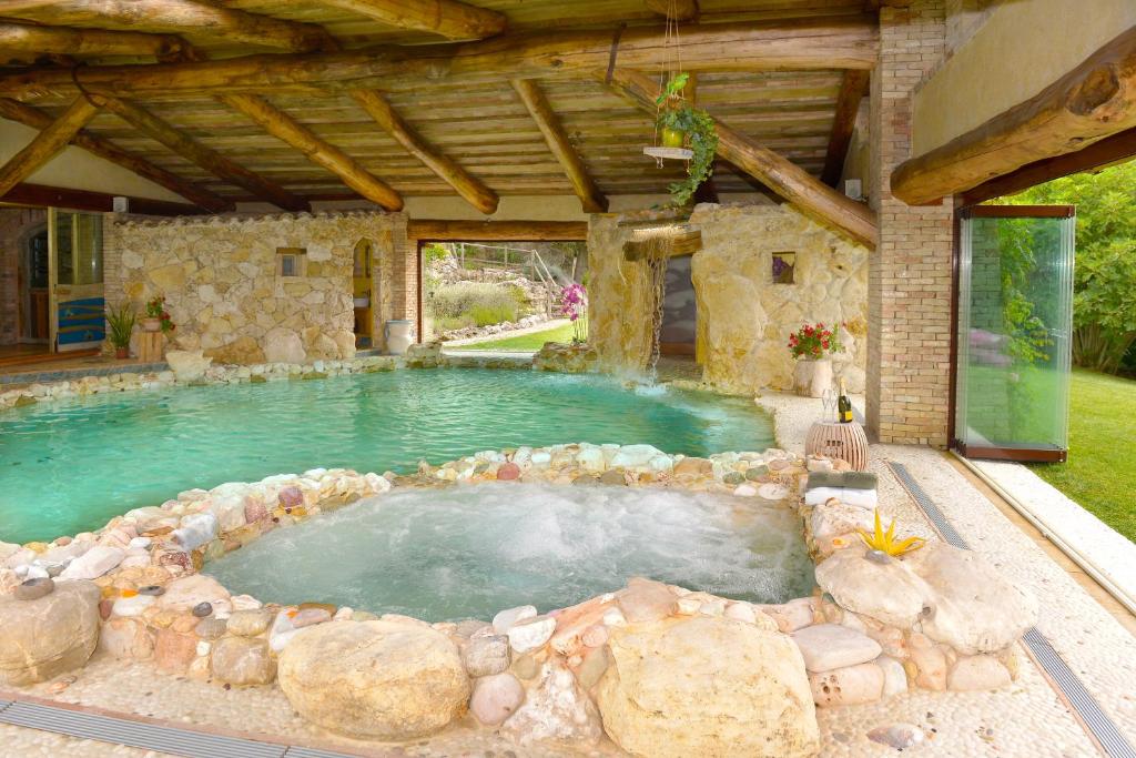 GuardeaにあるLuxury villa Colle dell'Asinello ,proprietari ,Price villa In esclusiva ed all inclusive area SPA h24 , Pool Heating 31 C , near ORVIETOの大型スイミングプール(周囲に岩あり)