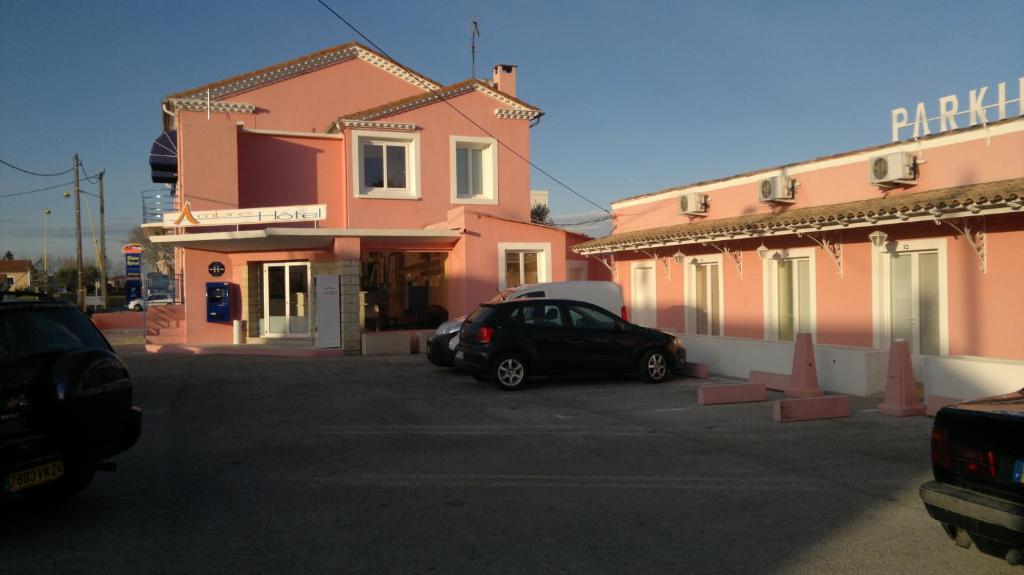 a car parked in a parking lot in front of a building at Ambre Hotel in Lunel