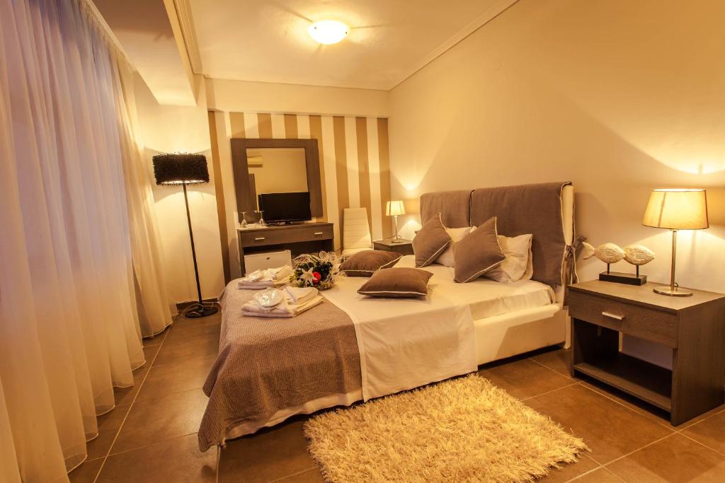 ネア・カリクラティアにあるAqua Mare Sea Side Roomsのベッドと鏡が備わるホテルルーム