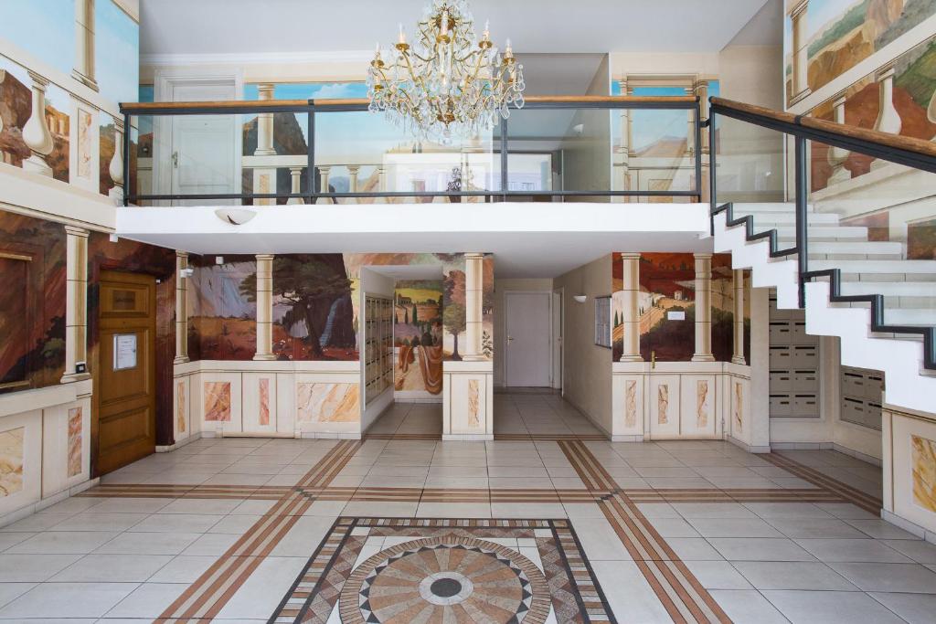 カンヌにあるPalazzio Vieux Port by Welcome to Cannesの階段とシャンデリアが備わる広い客室です。