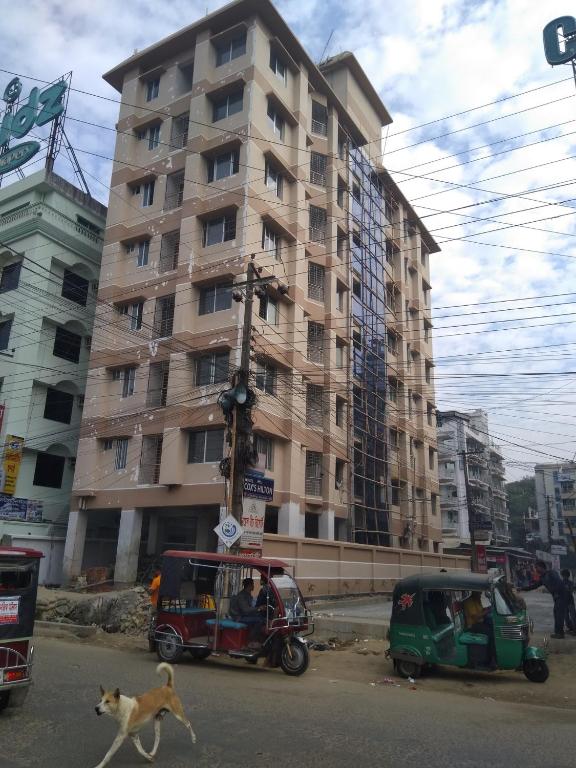 a dog crossing a street in front of a building at Water Paradise Resort in Cox's Bazar