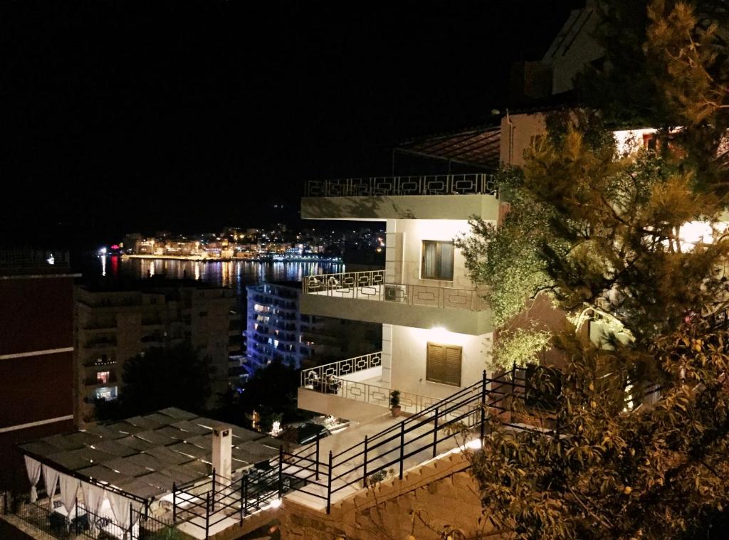 a building at night with a view of the water at Jericho Rooms in Sarandë
