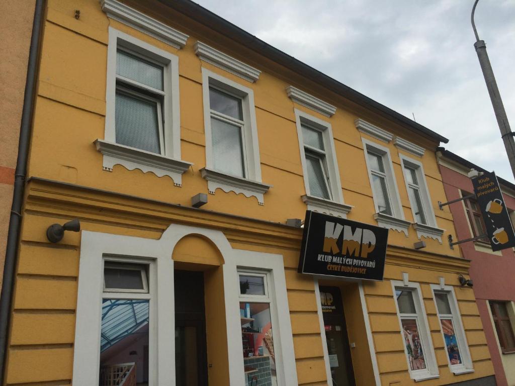 żółty budynek z znakiem przed nim w obiekcie Hostel Klub malých pivovarů w Czeskich Budziejowicach