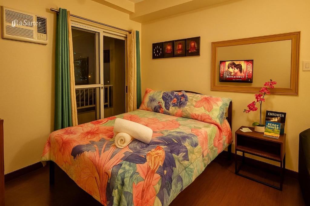a bedroom with a bed with a flower pattern at La Verti Residences Unit 1420 I Skyline Views & Luxe Stay Near MOA in Manila