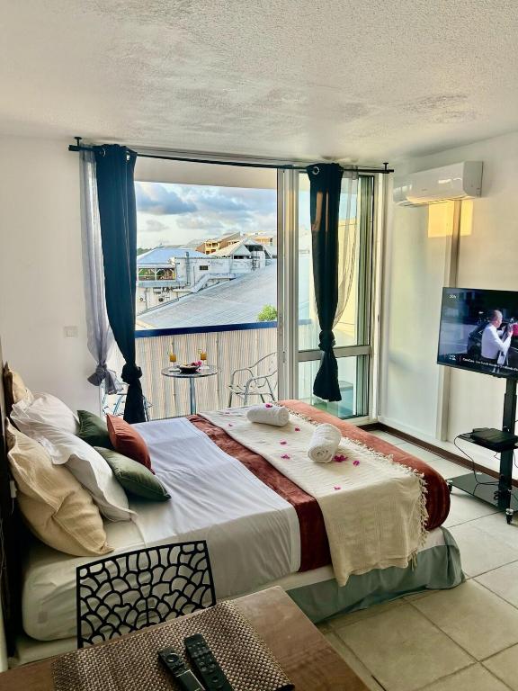 a bedroom with a large bed with a large window at Kimia studio 2 pas de la plage au Gosier in Le Gosier