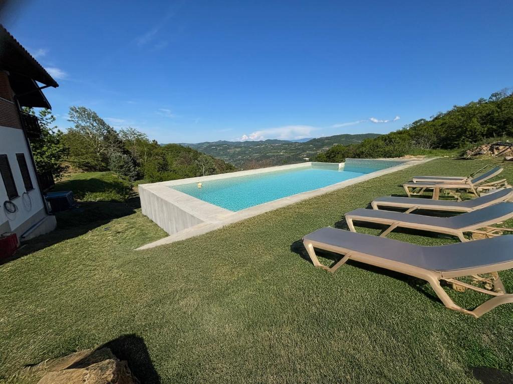 a group of lawn chairs and a swimming pool at Case Vista Alta Langa, Studio Bormida in Cravanzana