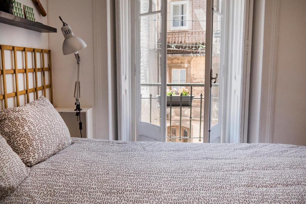 a bedroom with a bed and a large window at R & Freud Guest House in Lisbon