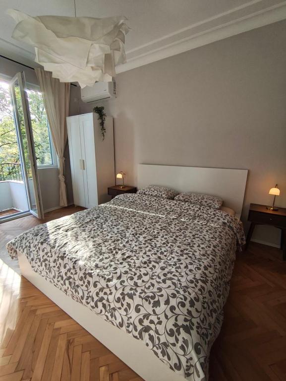 a bedroom with a bed with a black and white comforter at Serenity Lodge, next to NDK in Sofia