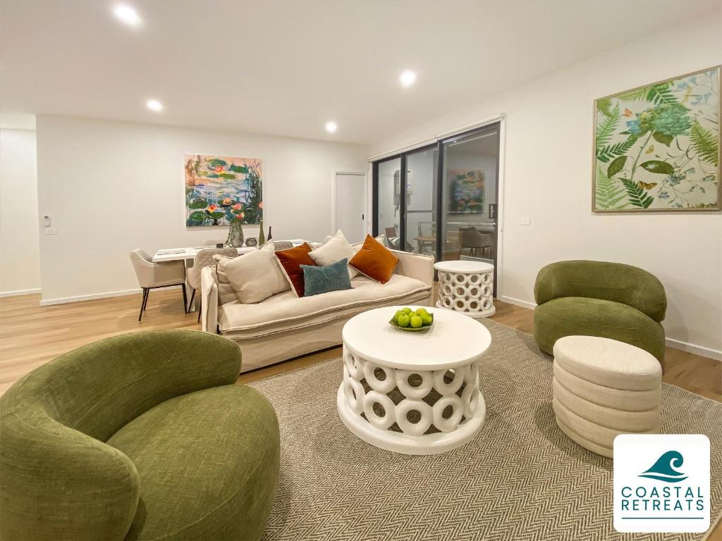 a living room with green chairs and a couch at Rilley Retreat Inverloch, Luxe Townhouse Near Beach in Inverloch