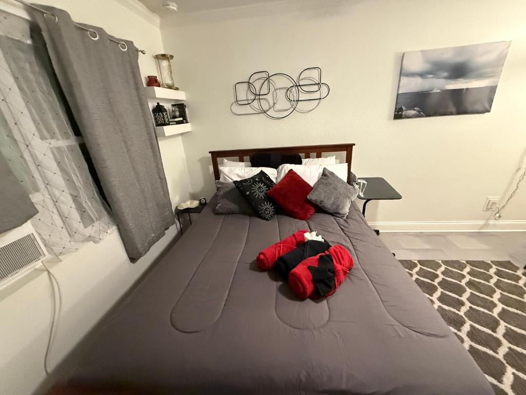 een groot grijs bed met een rood knuffeldier erop bij Short Walk to Raymond James Stadium in Tampa
