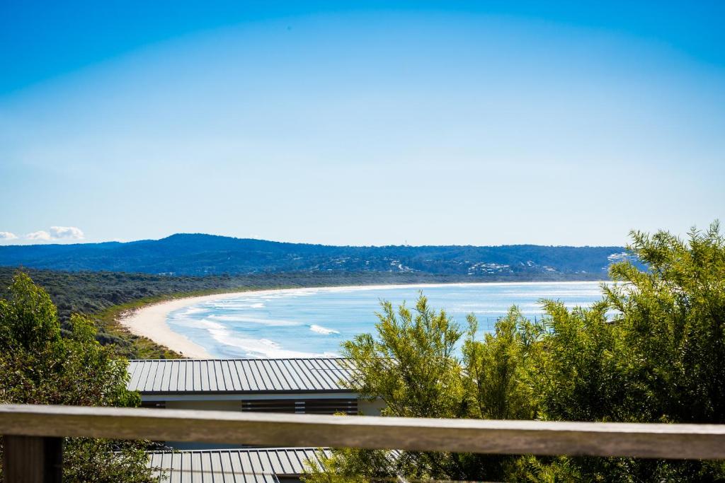 a view of a beach with a building and the ocean at The Love Shack in Pambula