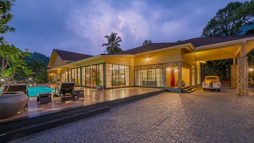 a large house with a swimming pool at The Ranch Kakkadampoyil - a VKation Experience in Kakkadampoyil