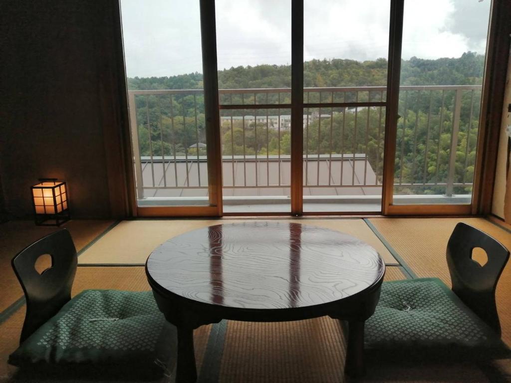 a room with a table and chairs and a large window at Fujiya in Sango