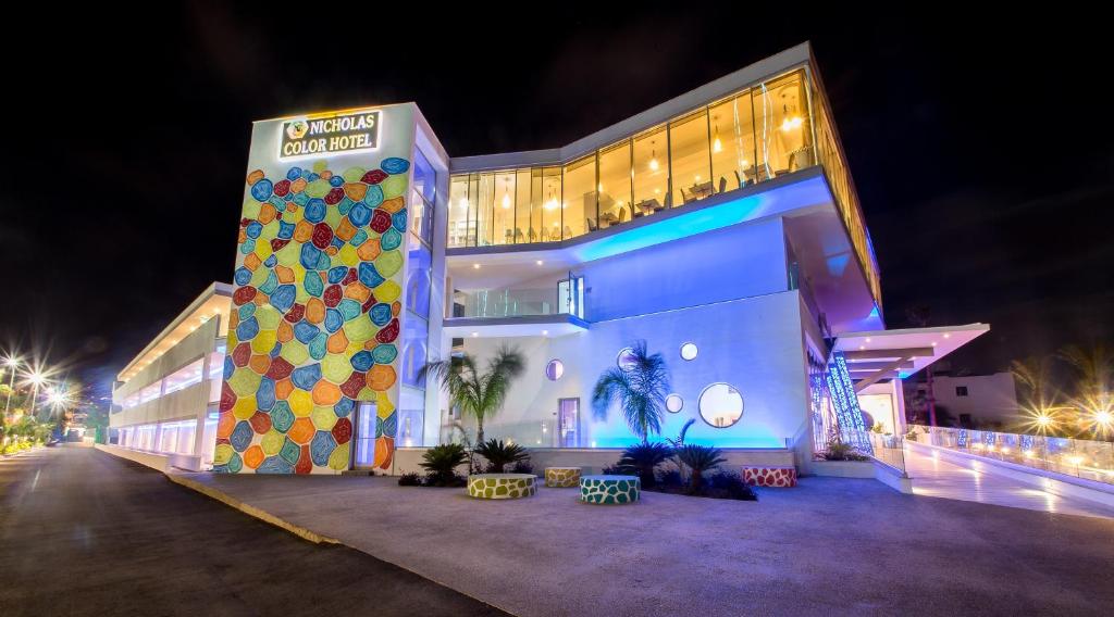a large white building with a building with a painting on it at Nicholas Color Hotel in Ayia Napa